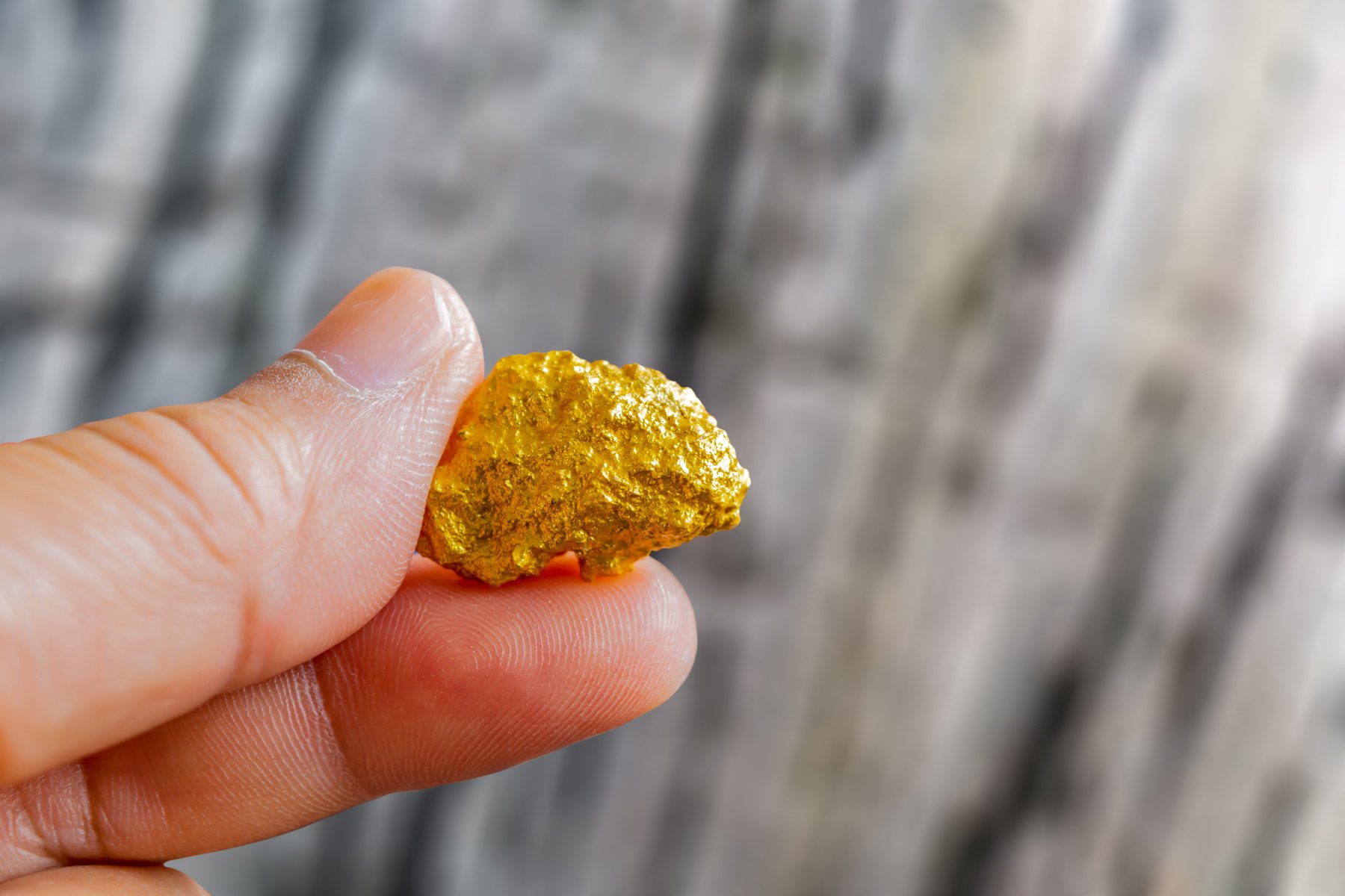 hand holding a pure gold nugget found in mine